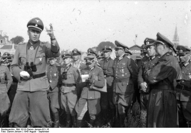 Wilhelm Bittrich con la mano derecha lesionada, habla con los oficiales de la Wehrmacht y los líderes de las Waffen-SS. Norte de Francia, agosto de 1943
